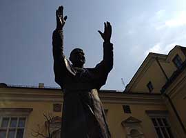 A statue of St. John Paul II with his arms raised in a greeting welcomes visitors to Krakow, Poland.