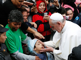 Pope Francis blesses a boy in the Varginha slum in Rio de Janeiro. (CNS photo/Paul Haring)
