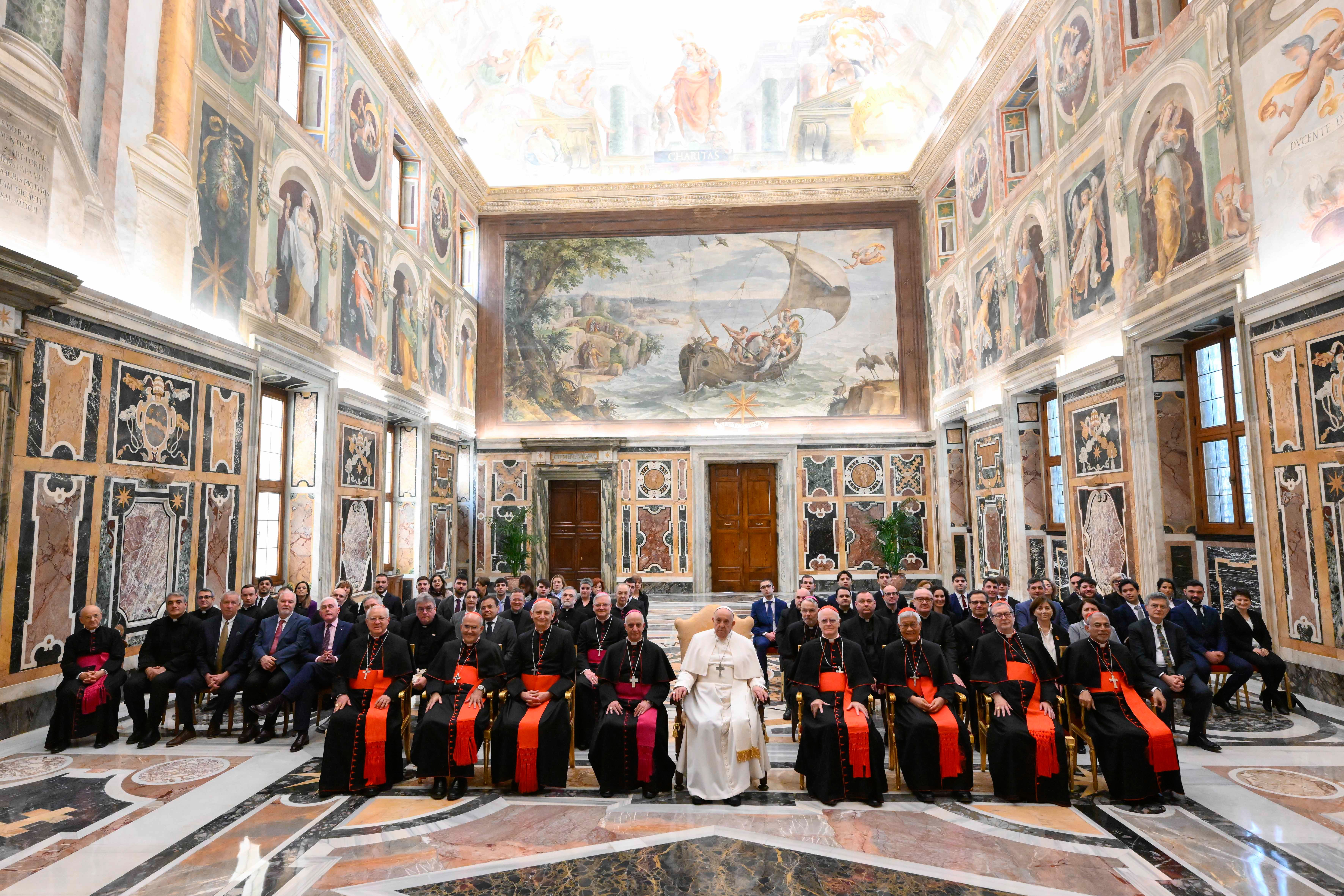 Pope Francis poses for a photo with members of the Dicastery for Evangelization.