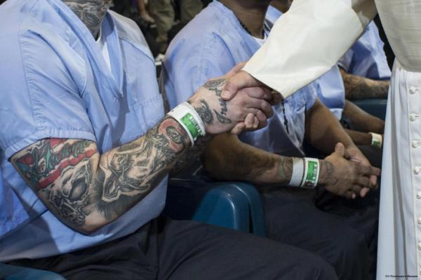 Pope Francis shakes hands of prisoner with tattoos