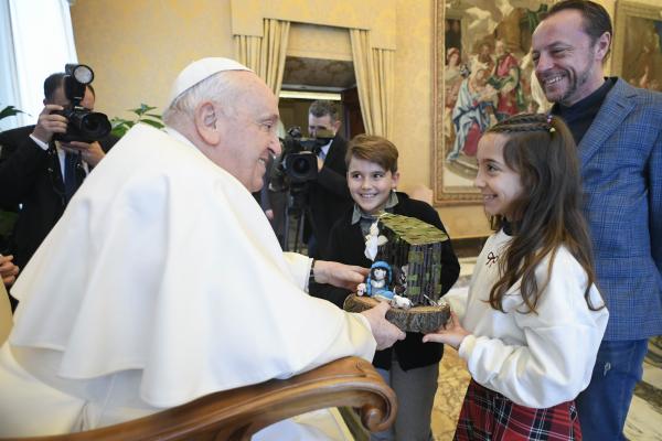 Pope Francis receives a gift from a child.