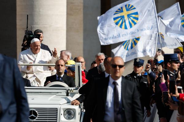 Pope Francis greets people as he rides the popemobile.